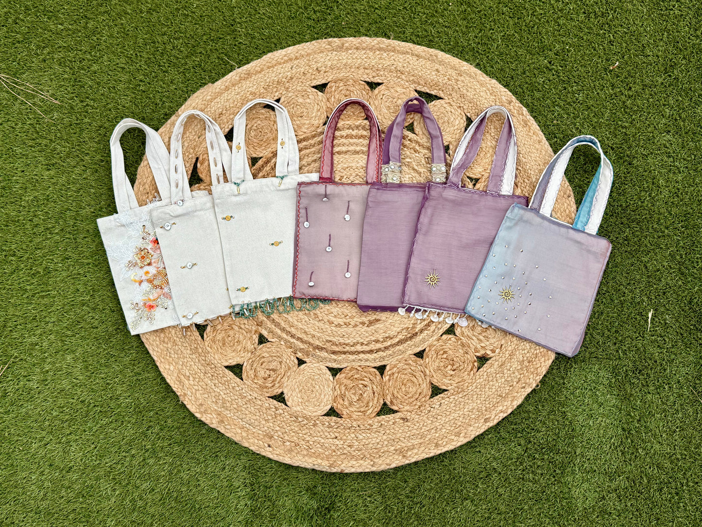 Set of small tote bags in various colors on a woven mat